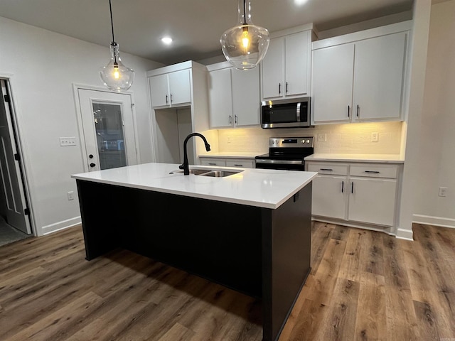 kitchen featuring white cabinetry, sink, decorative light fixtures, and appliances with stainless steel finishes