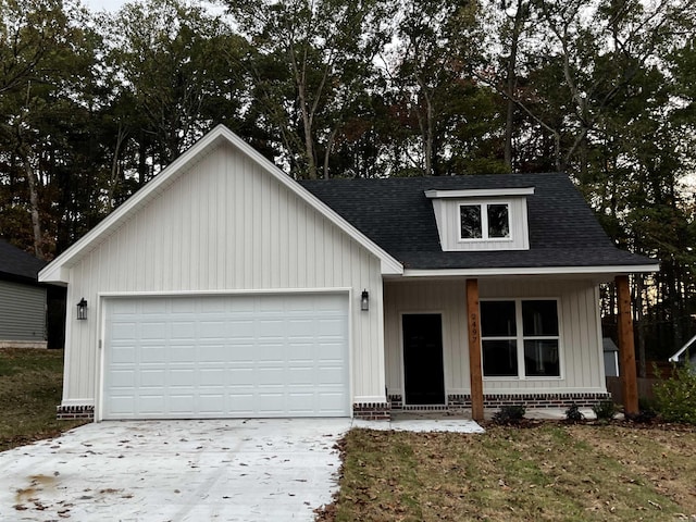 2497 Janet, Benton, AR 72015 - view of front facade featuring concrete driveway, an attached garage, a shingled roof, and board and batten siding