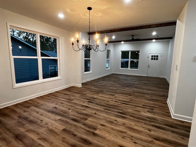 unfurnished dining area with ceiling fan with notable chandelier and dark hardwood / wood-style flooring