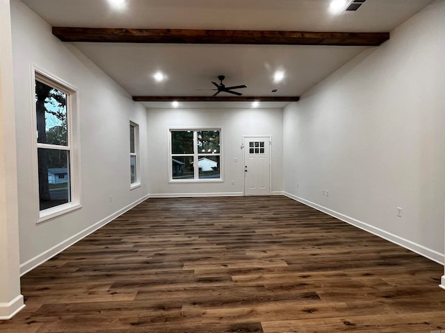 spare room featuring dark wood-type flooring, ceiling fan, and beam ceiling