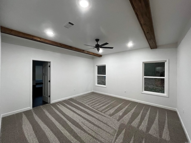 spare room featuring beamed ceiling, ceiling fan, and dark carpet