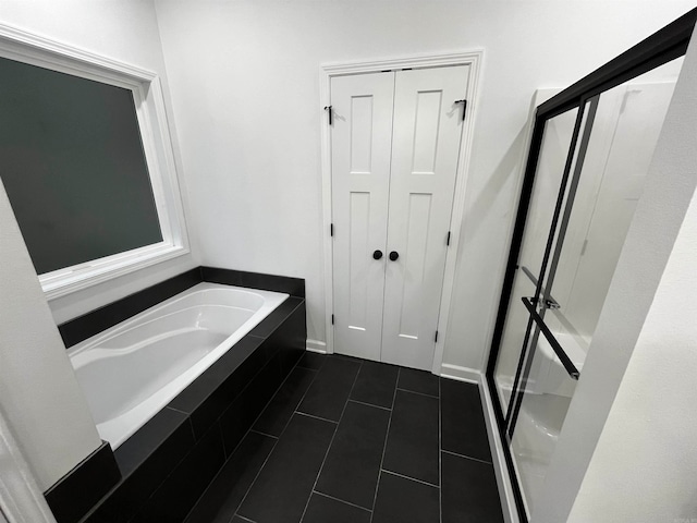 bathroom featuring tile patterned floors and tiled tub