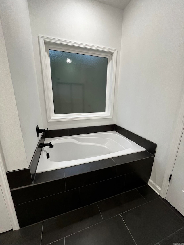 bathroom with tiled bath and tile patterned floors