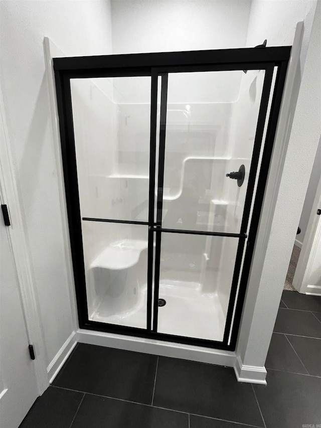 bathroom featuring an enclosed shower and tile patterned flooring