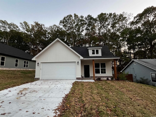 view of front facade featuring covered porch, a garage, and a front yard