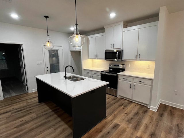 kitchen with stainless steel appliances, white cabinets, sink, a kitchen island with sink, and dark hardwood / wood-style floors