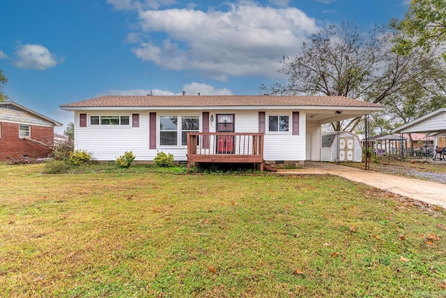 back of property featuring a lawn, a carport, a shed, and a wooden deck