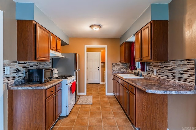 kitchen featuring light tile patterned floors, sink, decorative backsplash, and white range with gas stovetop