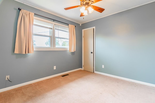 unfurnished room with ceiling fan, crown molding, and carpet