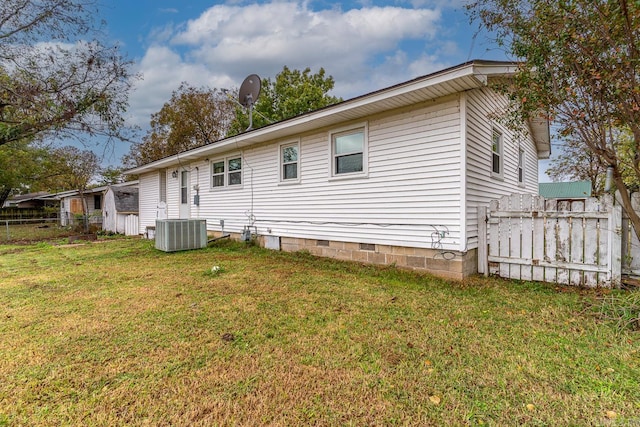 rear view of property featuring central AC and a yard