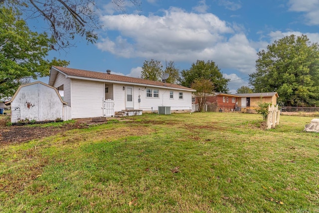 rear view of property featuring a lawn and central AC