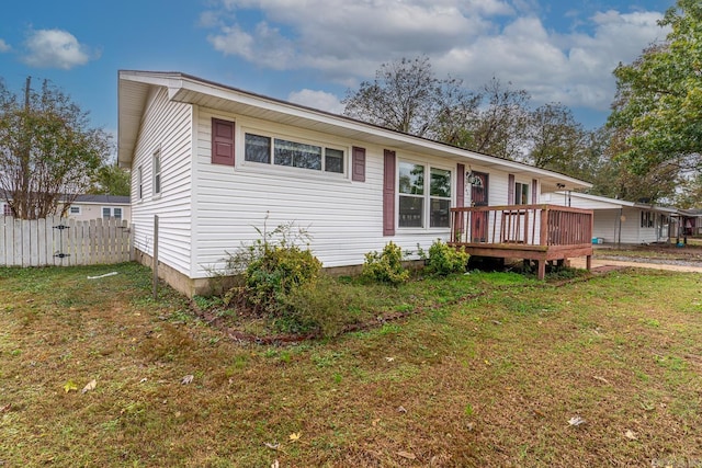 view of front facade featuring a front lawn and a wooden deck