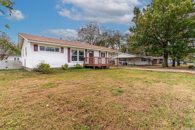 ranch-style house featuring a front lawn and a deck