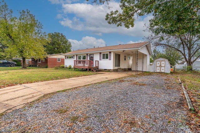 view of front of property featuring a front yard, a wooden deck, and a storage shed