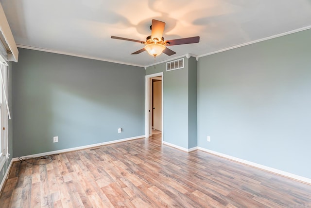 spare room with light wood-type flooring, ceiling fan, and crown molding