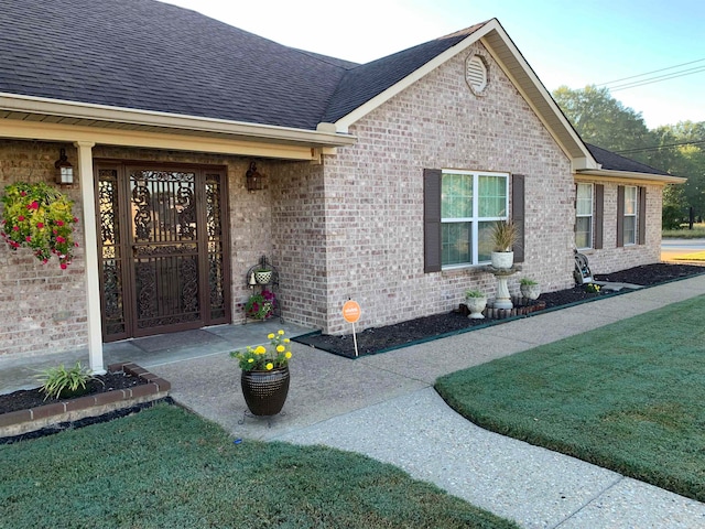 view of exterior entry featuring a yard