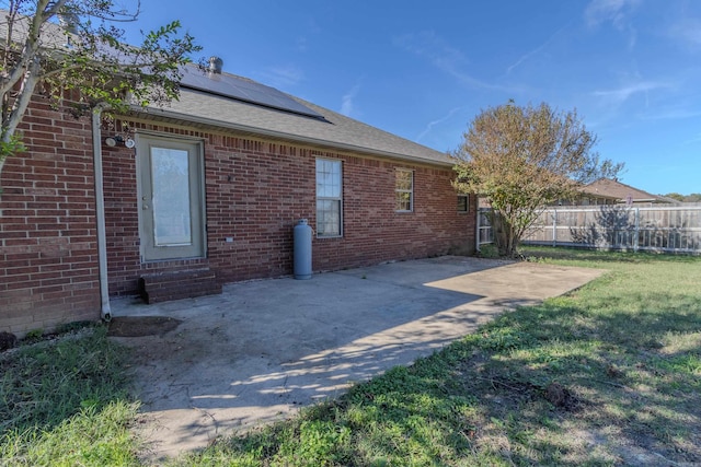 back of house with a patio and a lawn