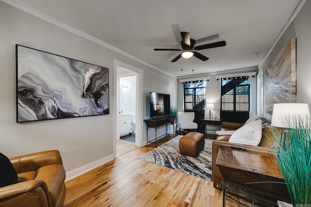 living room featuring ornamental molding, light wood-type flooring, and ceiling fan