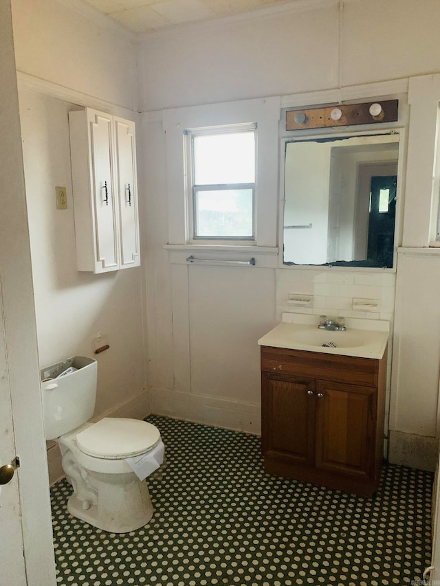 bathroom featuring toilet, backsplash, and vanity