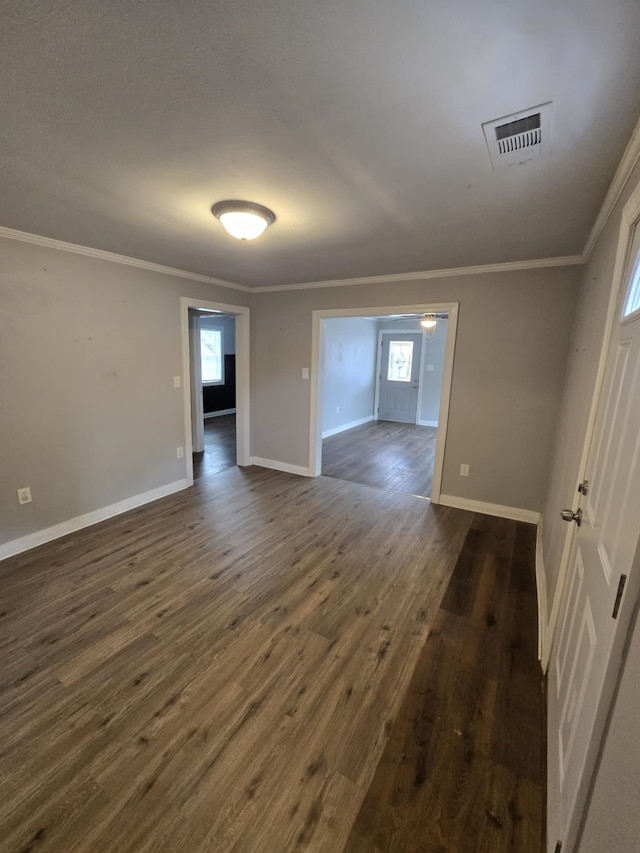 empty room featuring ornamental molding and dark hardwood / wood-style flooring