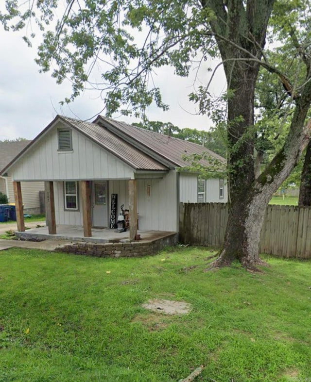 view of front of home with covered porch and a front lawn