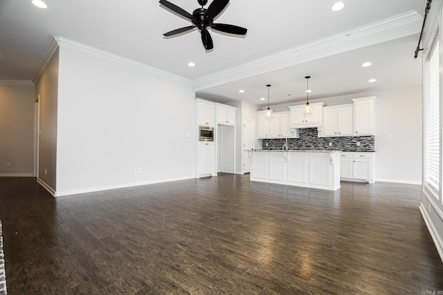 unfurnished living room with dark wood-type flooring, ceiling fan, and crown molding