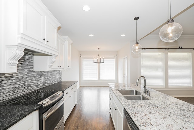 kitchen with dark stone countertops, sink, pendant lighting, and appliances with stainless steel finishes