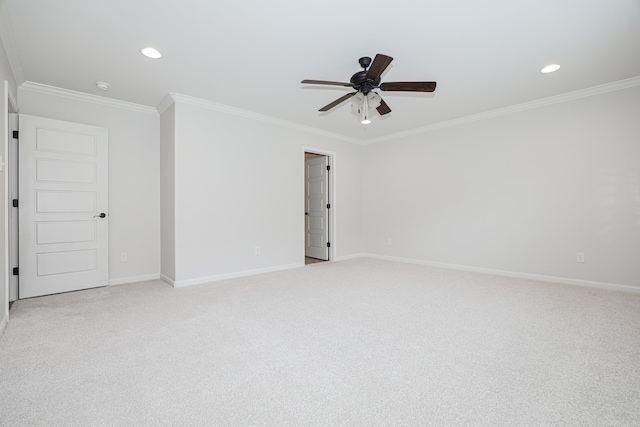 empty room with ceiling fan, light colored carpet, and crown molding