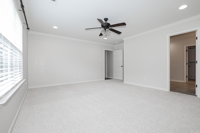 spare room featuring light carpet, ceiling fan, and crown molding