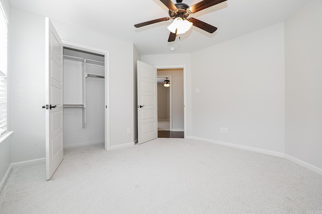 unfurnished bedroom with ceiling fan, light carpet, and a closet