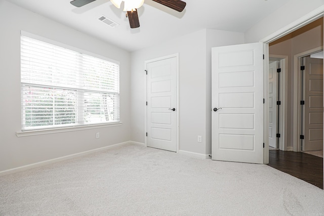 unfurnished bedroom with light colored carpet and ceiling fan