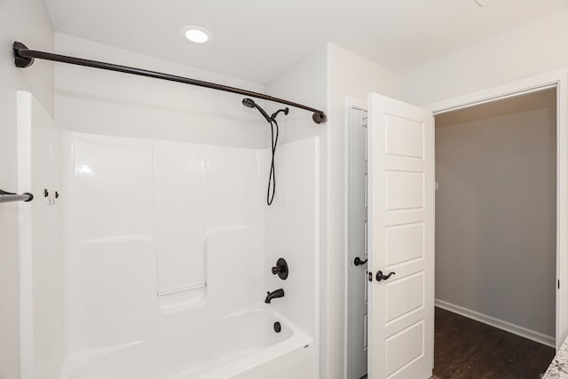 bathroom featuring wood-type flooring and shower / tub combination