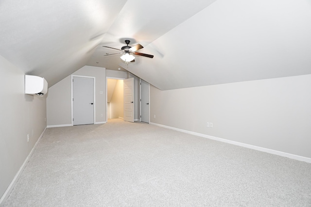 additional living space with lofted ceiling, a wall unit AC, light colored carpet, and ceiling fan