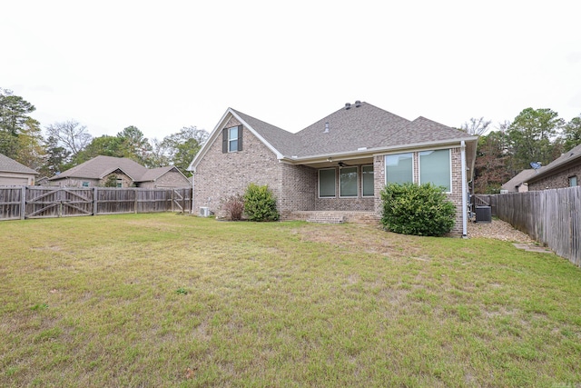 back of property featuring cooling unit, a lawn, and ceiling fan