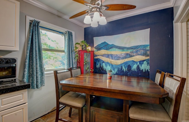 dining space with ornamental molding and ceiling fan