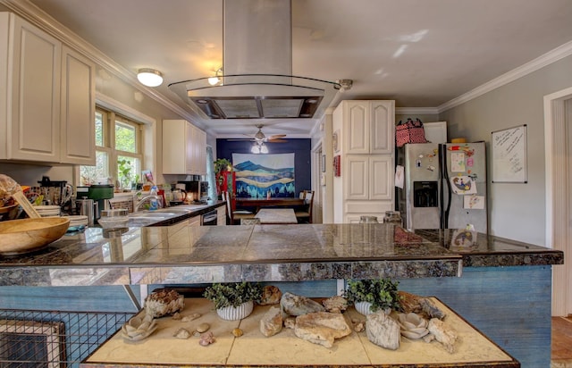 kitchen featuring kitchen peninsula, ornamental molding, ceiling fan, island exhaust hood, and stainless steel fridge with ice dispenser