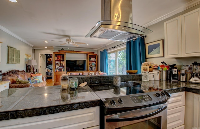 kitchen with crown molding, island exhaust hood, stainless steel range with electric cooktop, and ceiling fan