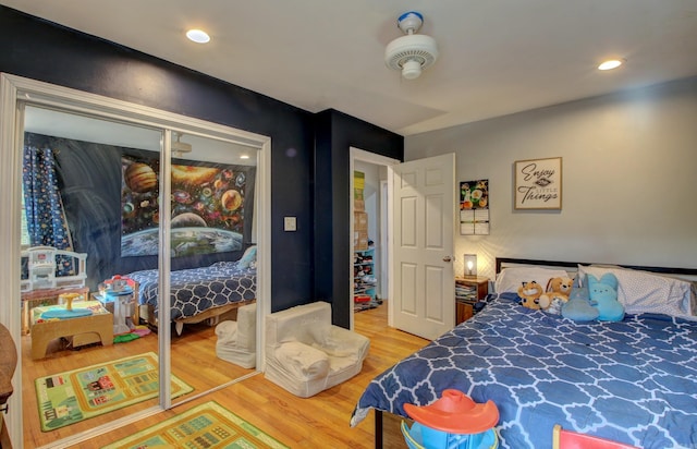 bedroom with hardwood / wood-style floors, ceiling fan, and a closet