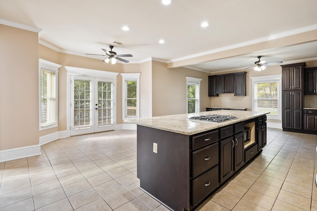 kitchen featuring french doors, stainless steel appliances, ornamental molding, a kitchen island, and dark brown cabinets