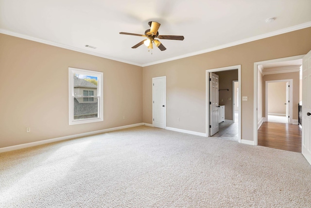 spare room with ceiling fan, light carpet, and crown molding