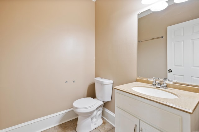 bathroom with toilet, vanity, and tile patterned floors