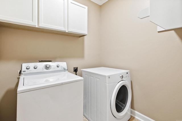 laundry area featuring cabinets and washing machine and clothes dryer