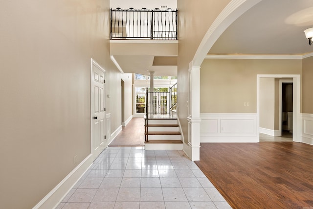 entryway with ornamental molding and light hardwood / wood-style floors