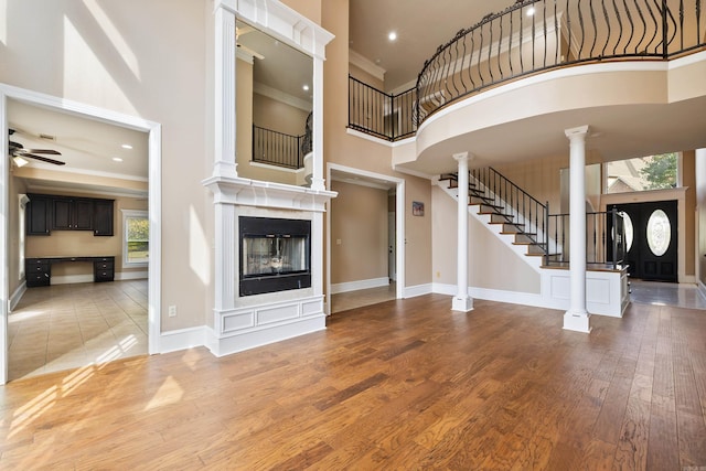 unfurnished living room featuring a high ceiling, a healthy amount of sunlight, and hardwood / wood-style flooring