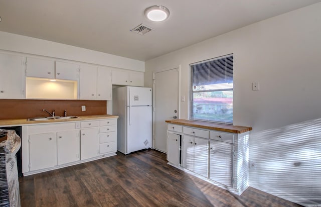 kitchen with dark hardwood / wood-style floors, white cabinetry, sink, and white refrigerator