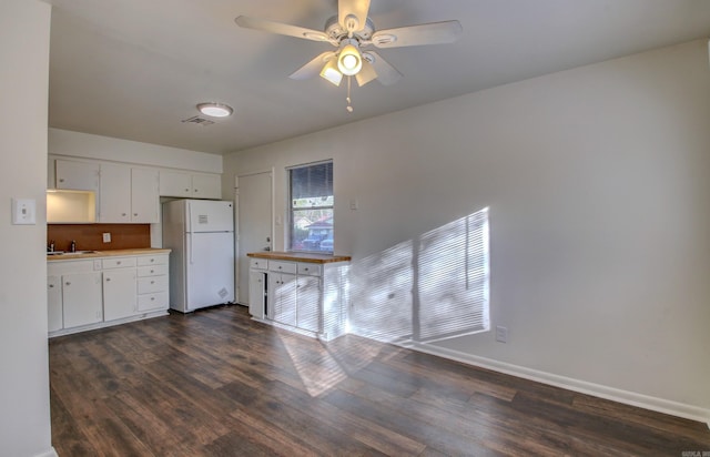 kitchen featuring dark hardwood / wood-style flooring, white refrigerator, sink, ceiling fan, and white cabinetry