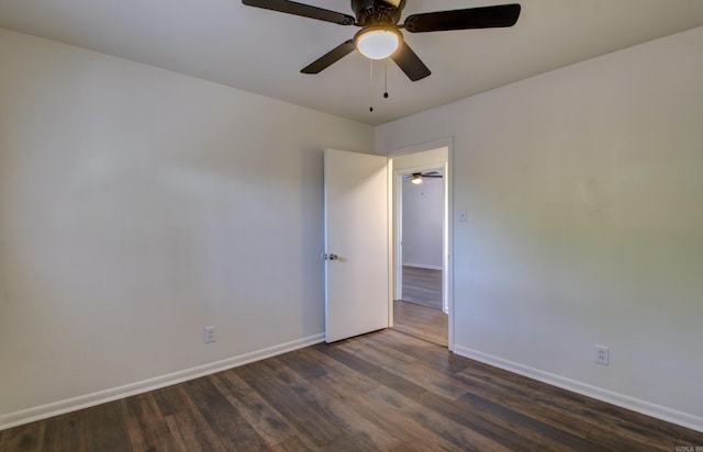 spare room featuring dark wood-type flooring and ceiling fan