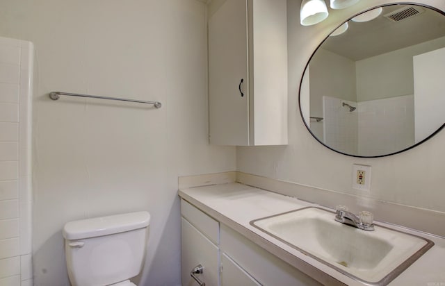 bathroom with toilet, a shower, and vanity