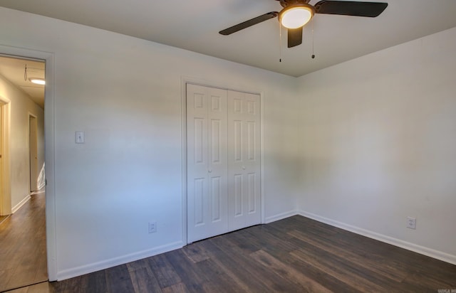 unfurnished bedroom featuring dark wood-type flooring, a closet, and ceiling fan