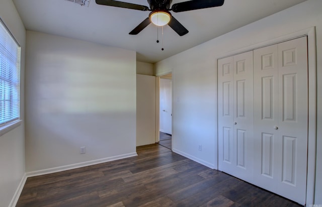 unfurnished bedroom featuring ceiling fan, a closet, and dark hardwood / wood-style flooring